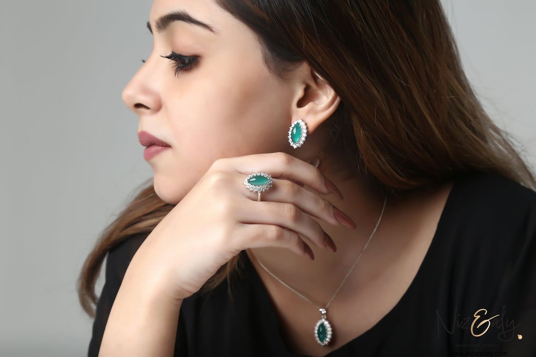 Niz & Aly marquise cut green chrysoprase pendant, ring, and earring set worn by a woman in a black top.