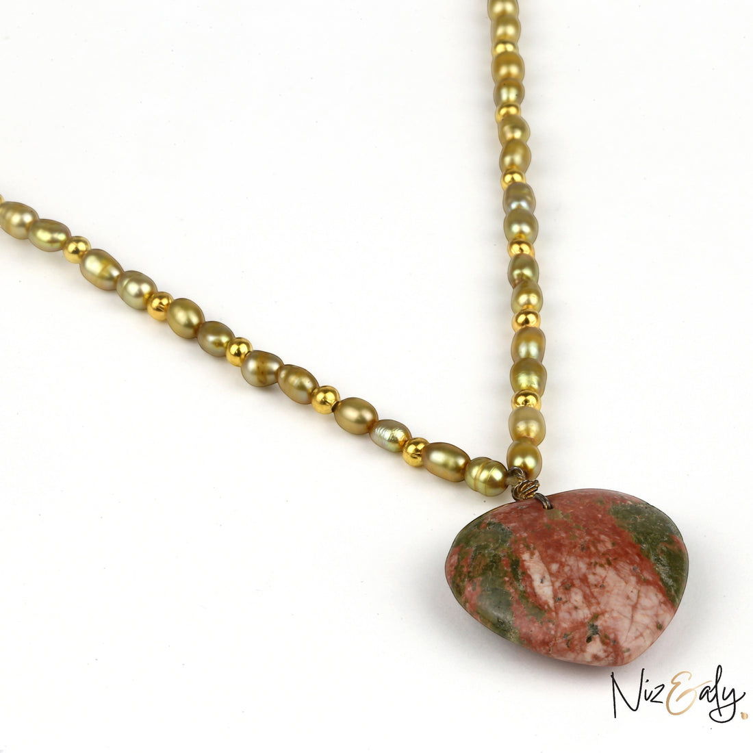 Niz & Aly necklace featuring a large heart-shaped red and green gemstone pendant on a strand of gold-toned pearl beads.