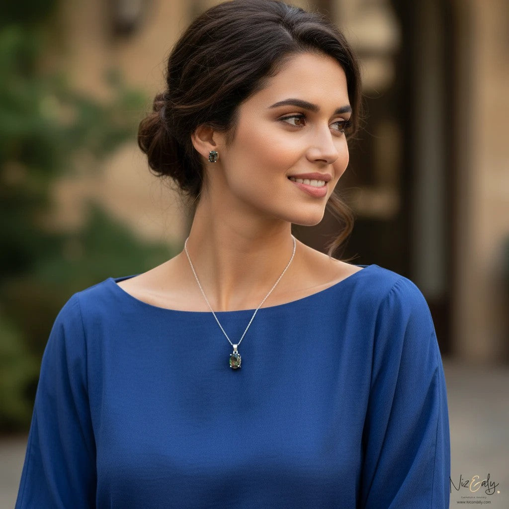 Niz & Aly solitaire iolite pendant and earring set worn by a woman in a blue top, featuring deep blue-violet gems.