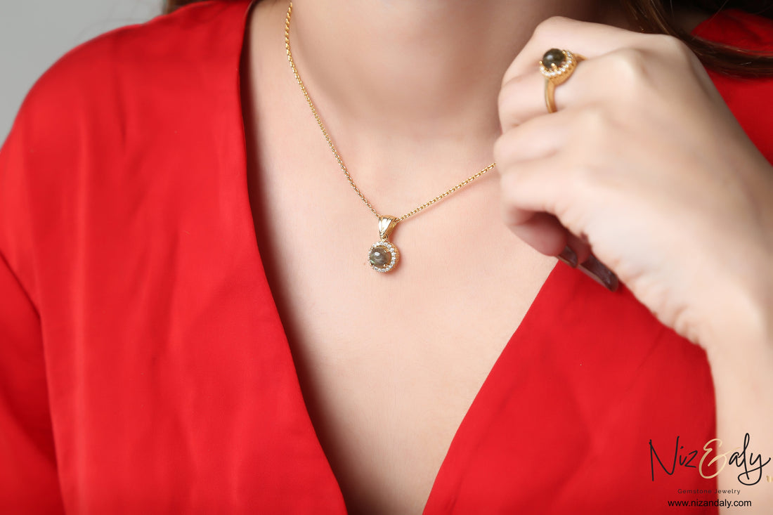 Niz & Aly dainty round labradorite pendant and matching ring set in gold-plated metal worn on a red top