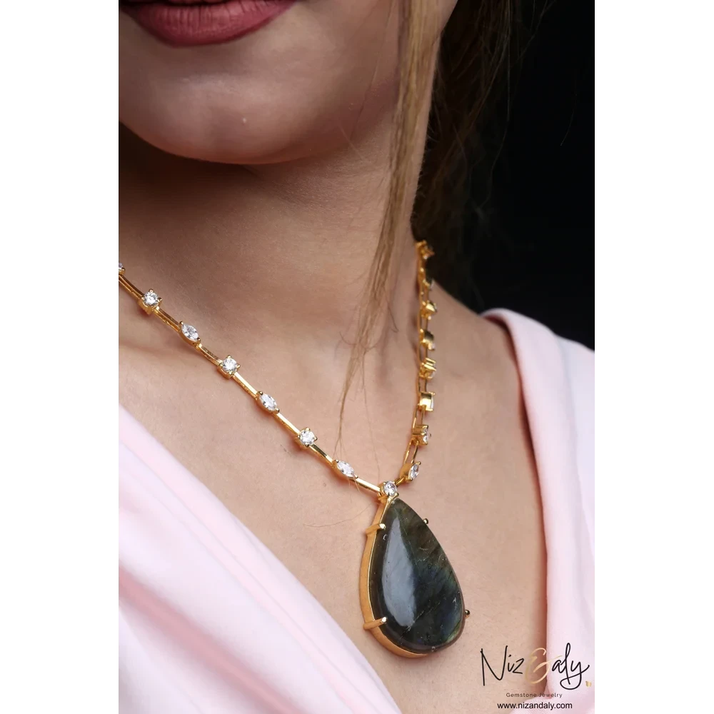 Niz & Aly teardrop labradorite pendant on a gold-toned chain with delicate crystal studs worn on a model