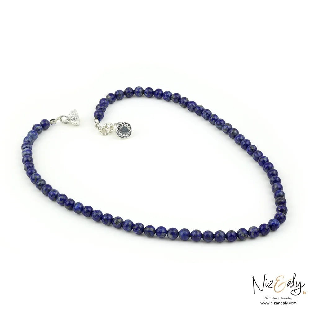 Niz & Aly Midnight Link necklace featuring deep blue lapis lazuli beads and a decorative silver magnetic clasp.