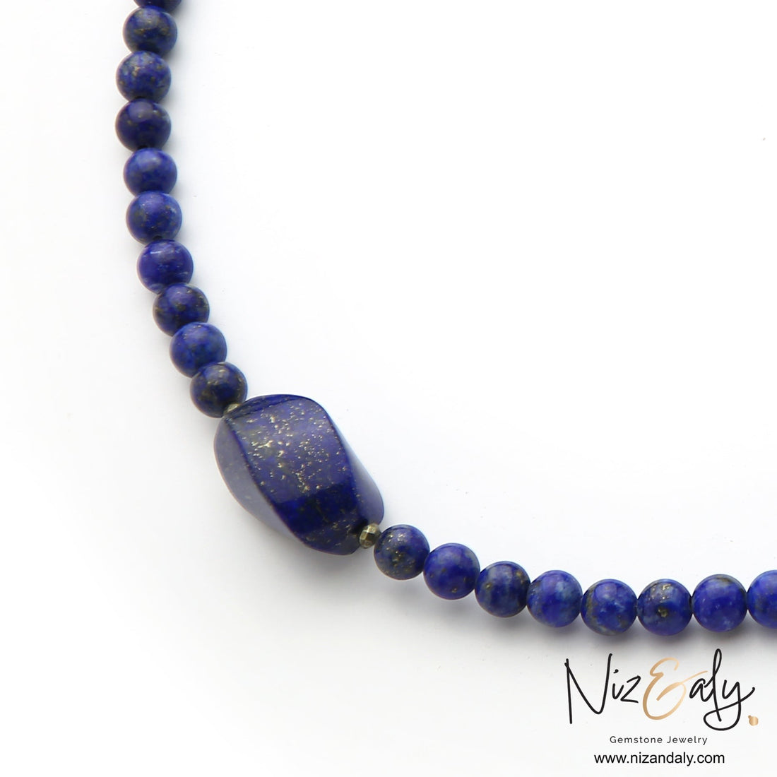 Niz & Aly Lapis Lazuli beaded necklace featuring a large deep blue gemstone with golden flecks on a white background