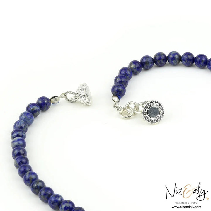 Niz & Aly Midnight Link necklace featuring deep blue lapis lazuli beads and a decorative silver magnetic clasp.
