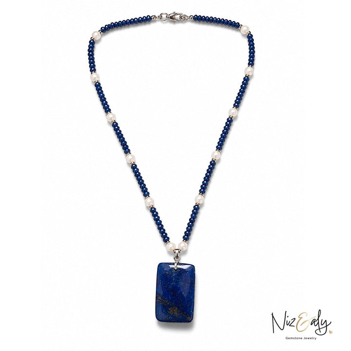 Niz & Aly necklace featuring deep blue lapis lazuli beads, white pearls, and a large rectangular lapis pendant.