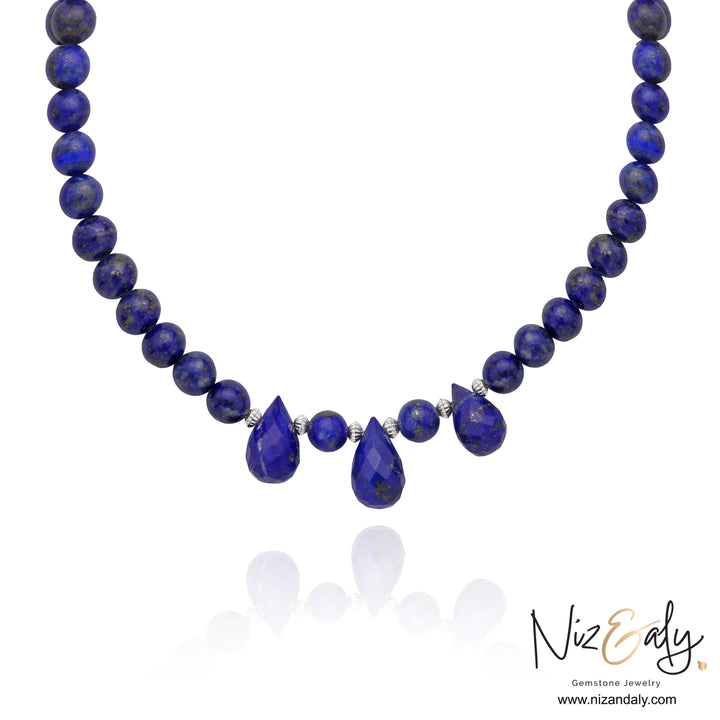 Niz & Aly handcrafted lapis lazuli necklace featuring deep blue round beads and three teardrop gemstone pendants.