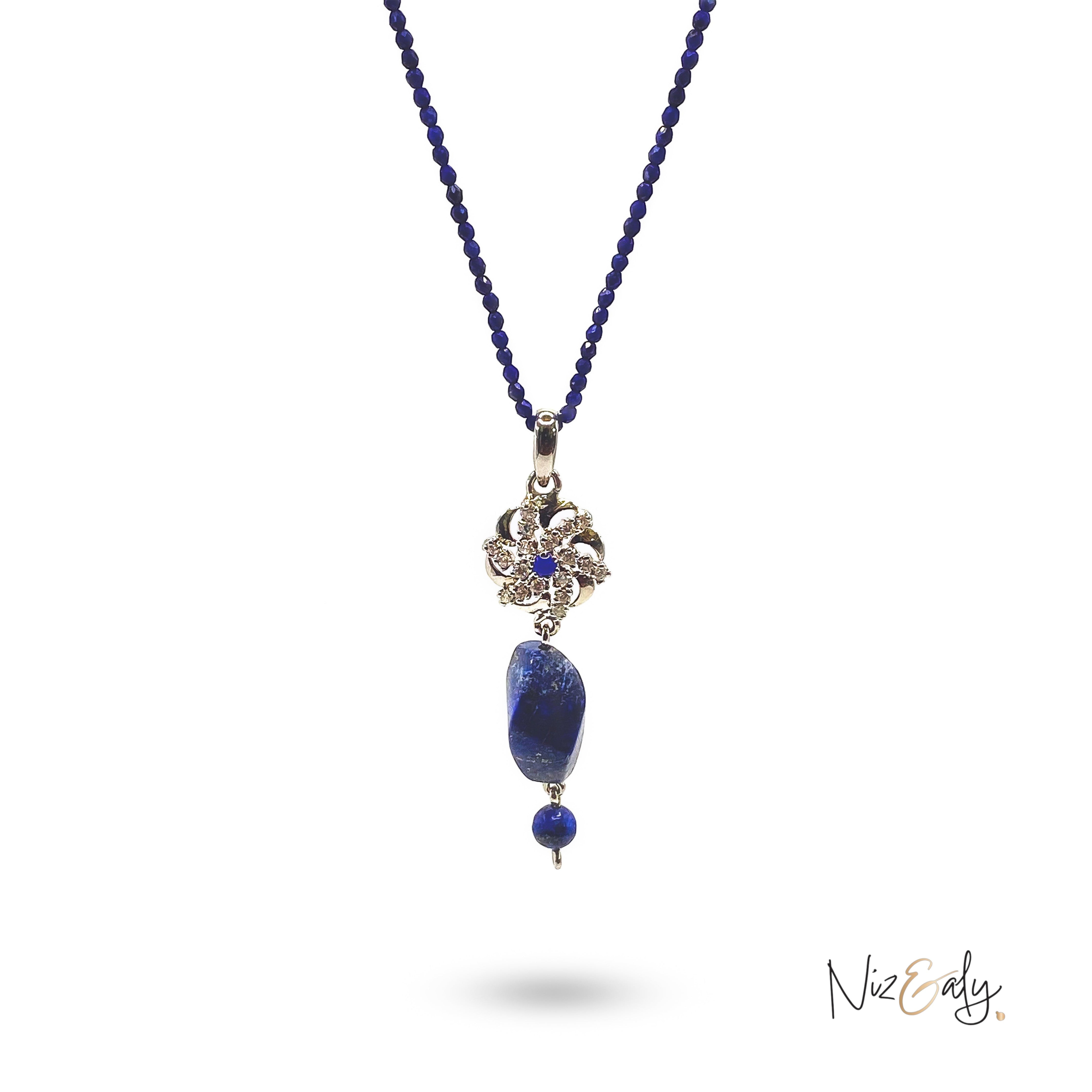 Niz & Aly lapis locket necklace featuring a faceted blue bead string and a decorative silver floral pendant.