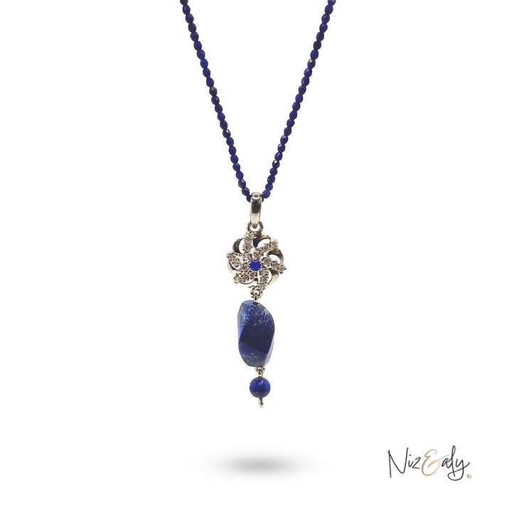 Niz & Aly lapis locket necklace featuring a faceted blue bead string and a decorative silver floral pendant.