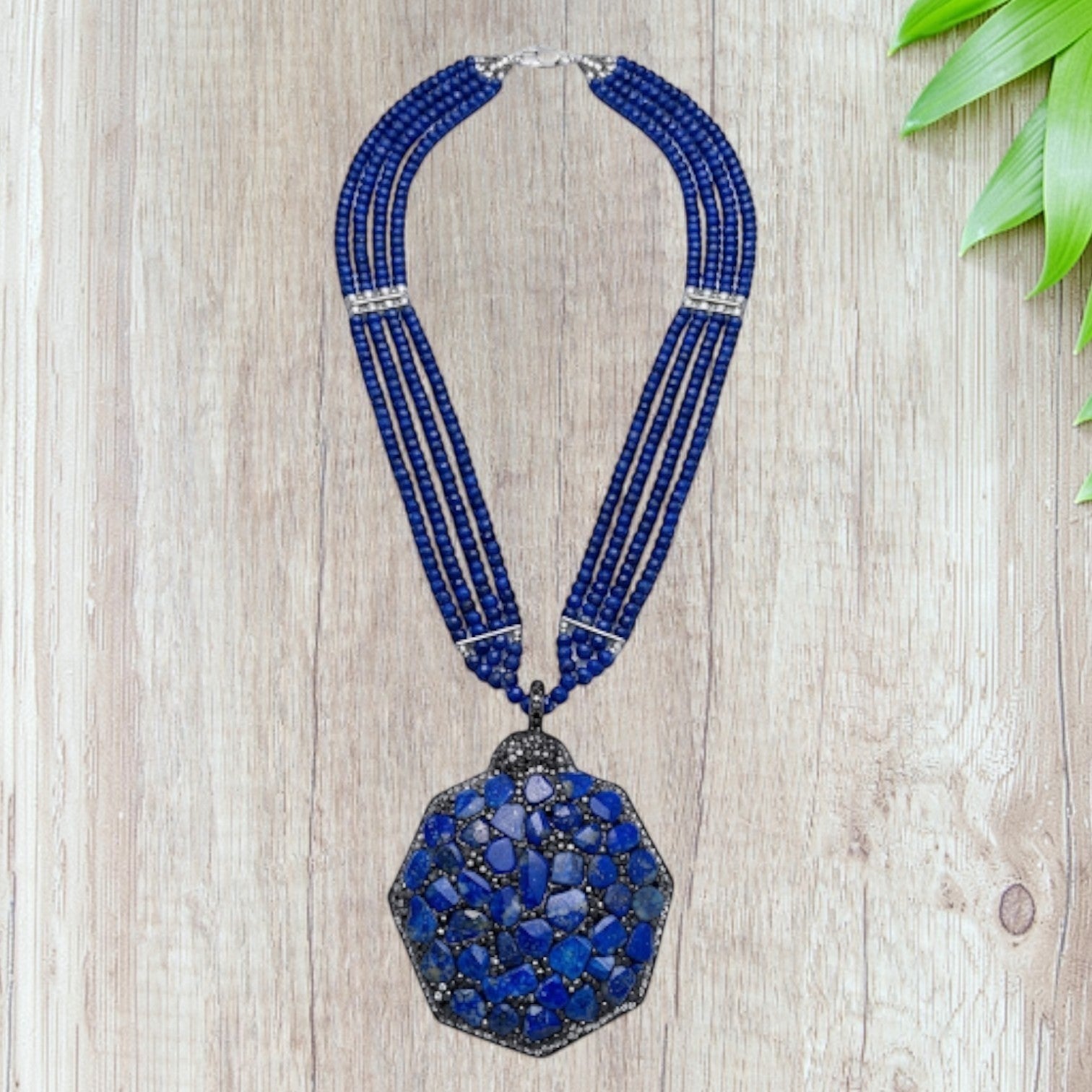 Niz & Aly statement necklace featuring three strands of blue quartz beads and a large hexagonal lapis lazuli pendant.