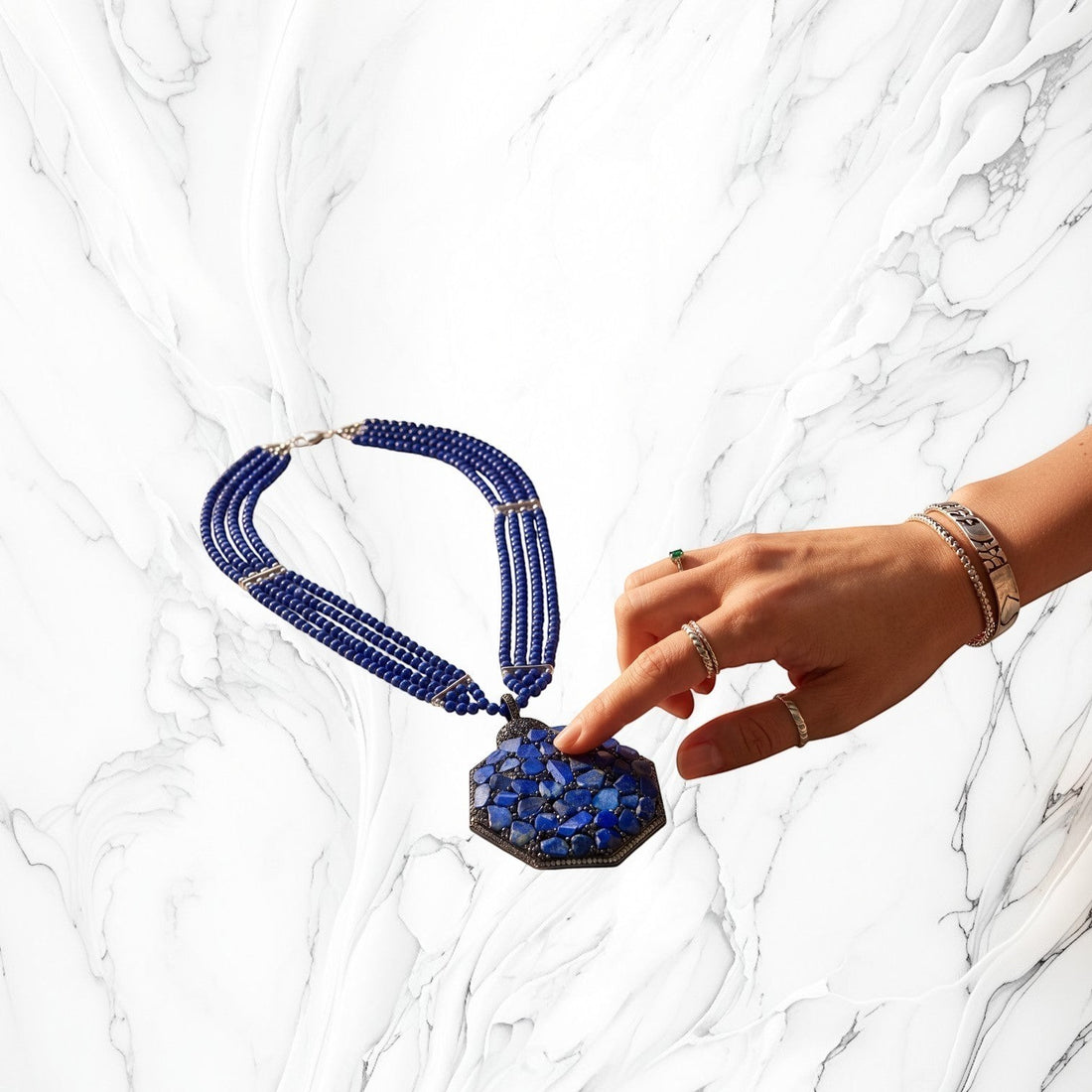 Niz & Aly statement necklace featuring three strands of blue quartz beads and a large lapis lazuli chip pendant.