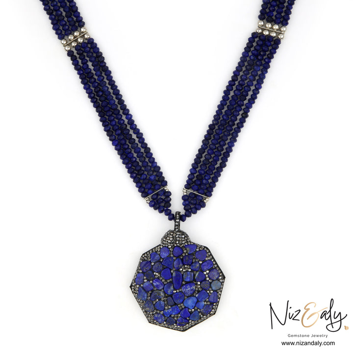 Niz & Aly statement necklace featuring three strands of blue quartz beads and a hexagonal lapis lazuli chip pendant.