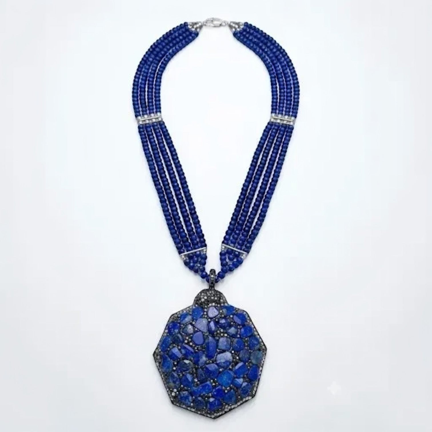 Niz & Aly statement necklace featuring three strands of blue quartz beads and a large hexagonal lapis lazuli pendant.