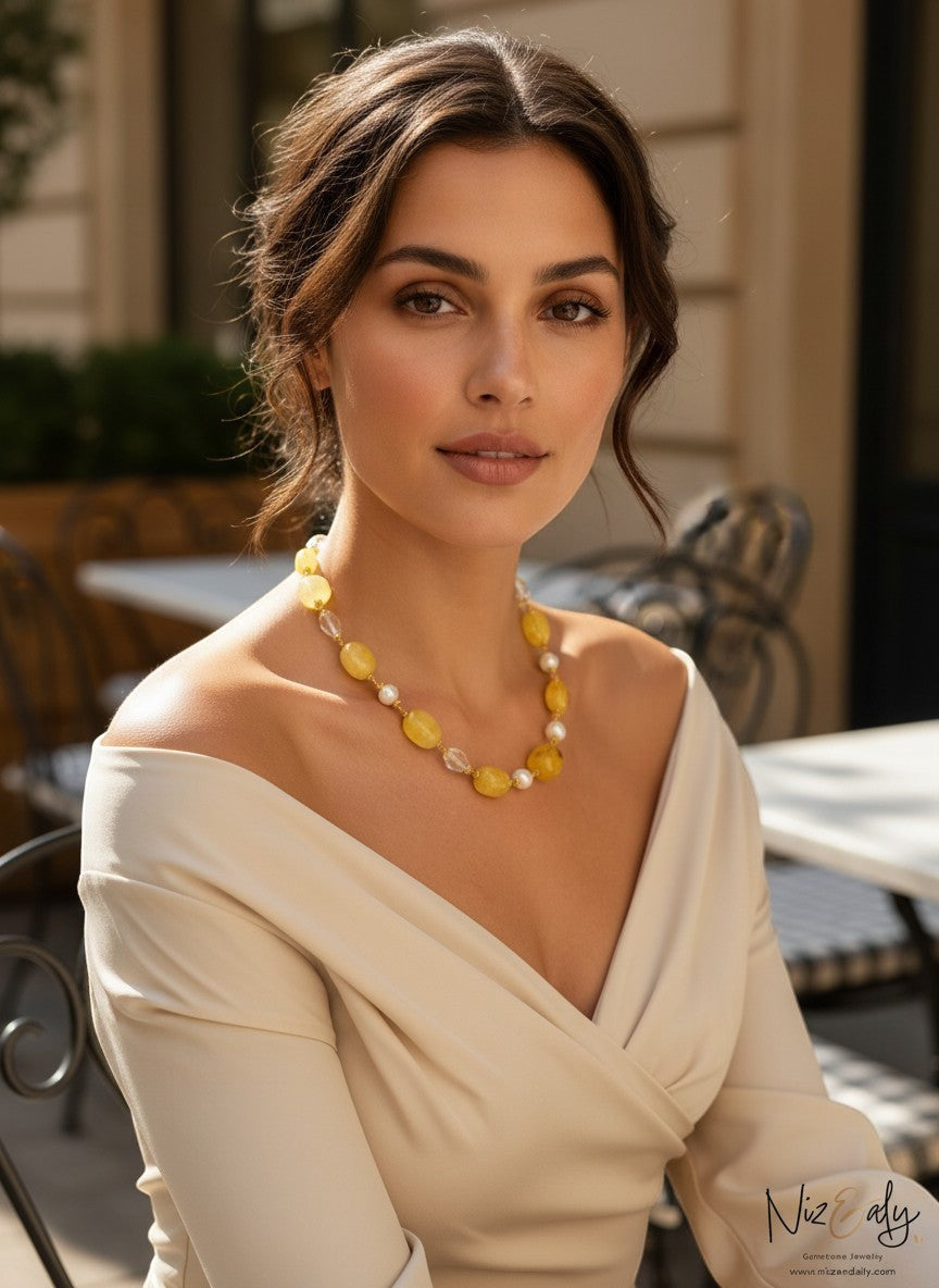 Niz & Aly necklace featuring lemon chiffon jade, icy quartz, and freshwater pearls worn by a woman in a beige top.