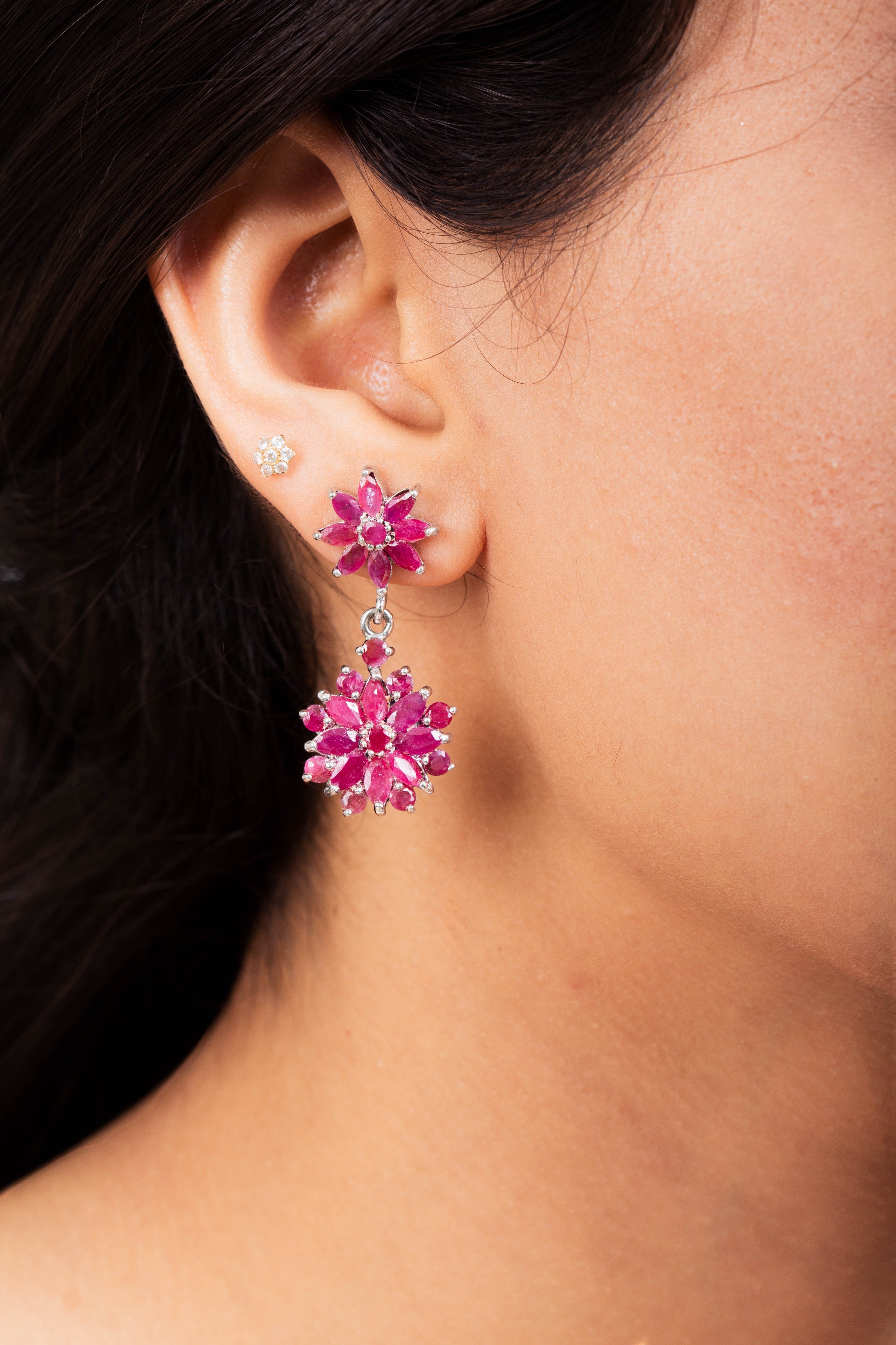 Niz & Aly marquise cut ruby drop earrings featuring a floral cluster design worn on a model's ear.