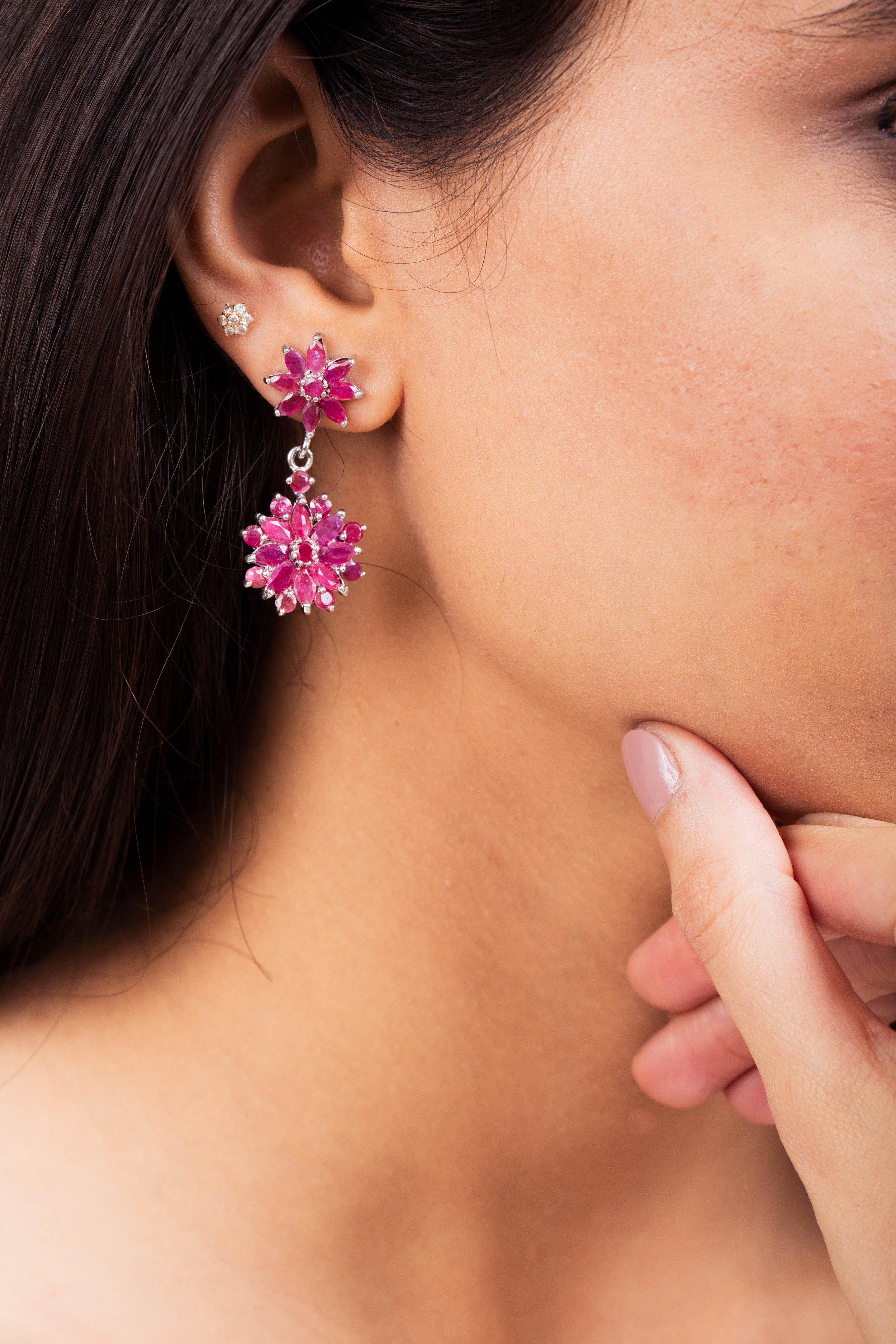 Niz & Aly marquise cut ruby flower drop earrings worn on a model, featuring deep red gemstones in a silver setting.