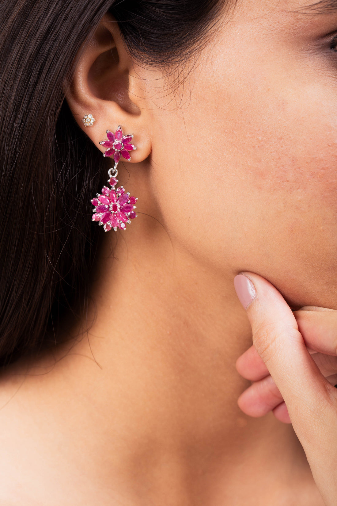 Niz & Aly marquise cut ruby flower drop earrings worn on a model, featuring deep red gemstones in a silver setting.