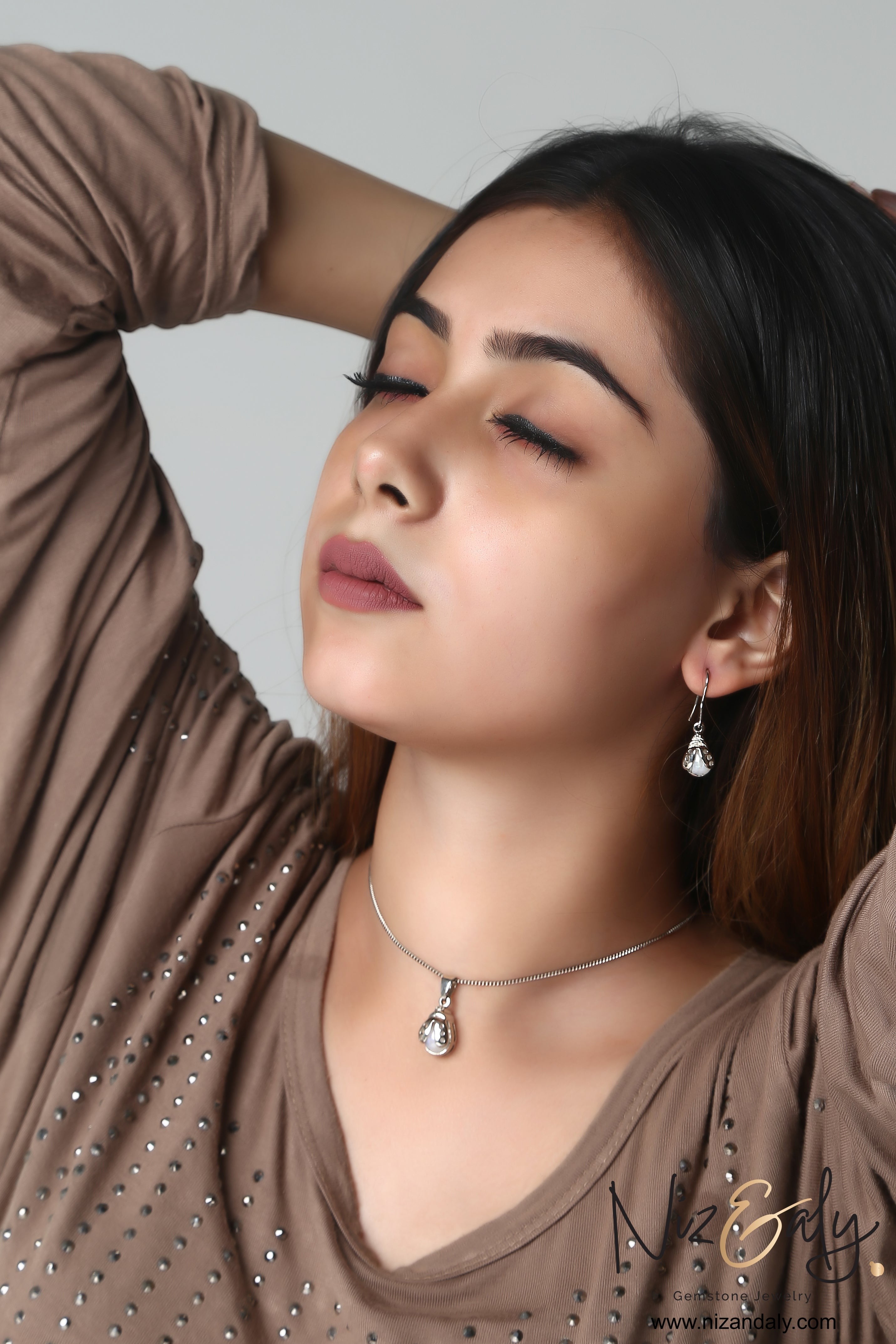 Niz & Aly moonstone bumble bee pendant and earring set worn by a woman with eyes closed, showcasing elegant jewelry.