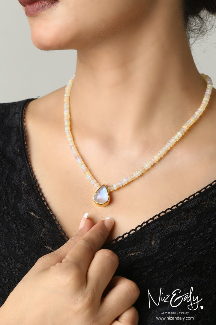 Niz & Aly necklace featuring a teardrop Rainbow Moonstone pendant on a strand of iridescent Ethiopian Fire Opal beads.