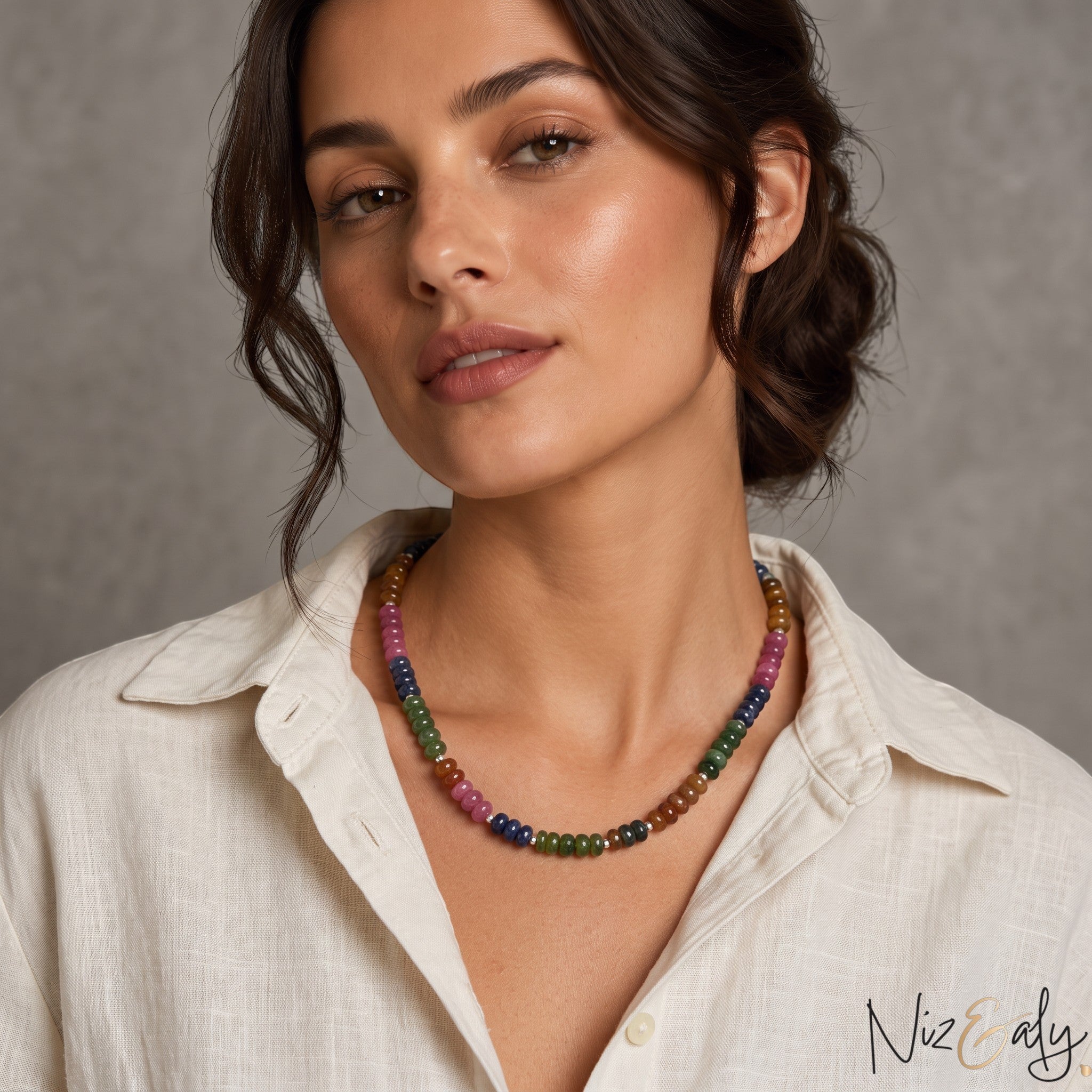Niz & Aly multicolored oval jade quartz beaded necklace worn by a woman in a white linen shirt.