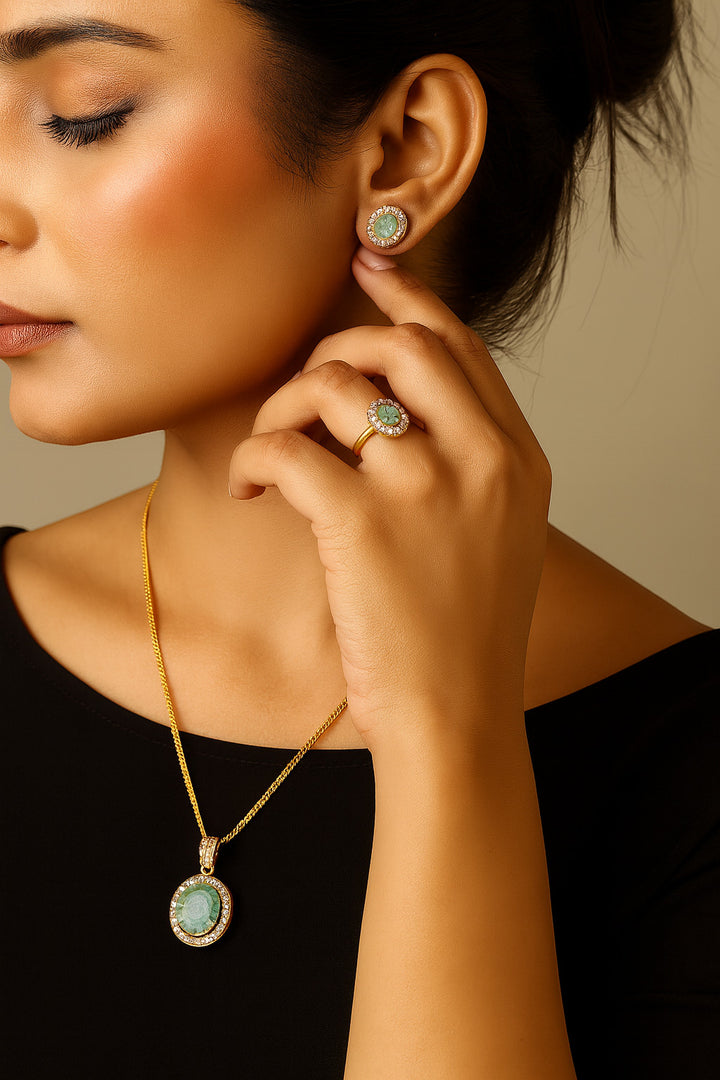 Niz & Aly Emeraude Halo set featuring a natural emerald pendant, stud earrings, and ring in gold-plated sterling silver.