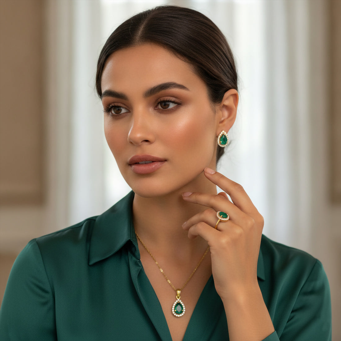 Niz & Aly teardrop emerald jewelry set with gold-plated sterling silver pendant, earrings, and ring on a model