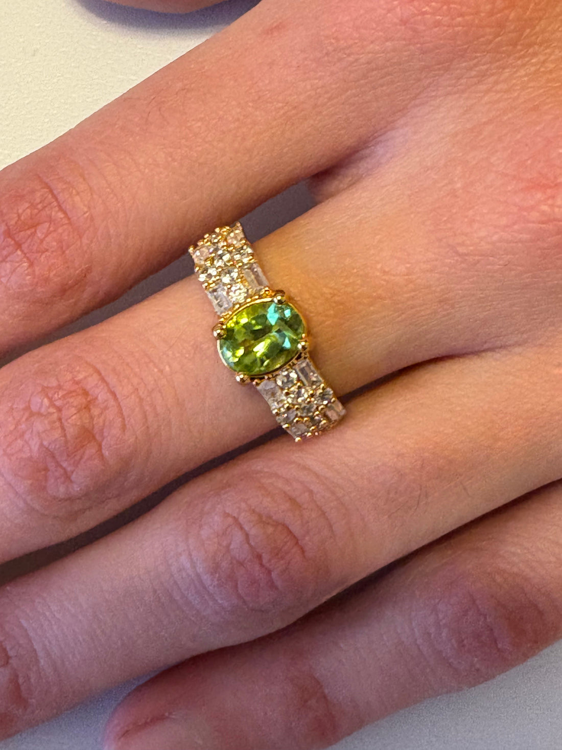 Niz & Aly adjustable gold-plated ring featuring an oval natural peridot gemstone and sparkling cubic zirconia accents.