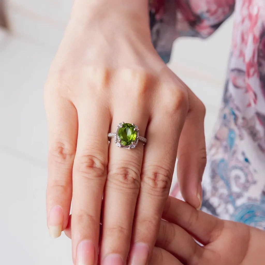 Niz & Aly Olive Bloom adjustable ring featuring an oval olive-green peridot gemstone on a delicate silver band.