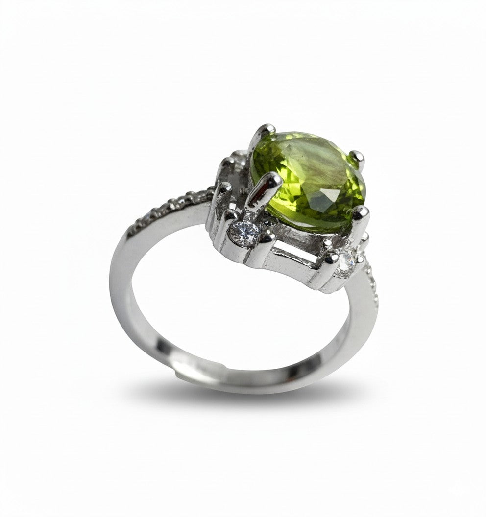 Niz & Aly Olive Bloom adjustable ring featuring an olive-green peridot gemstone and small accent stones on a silver band.