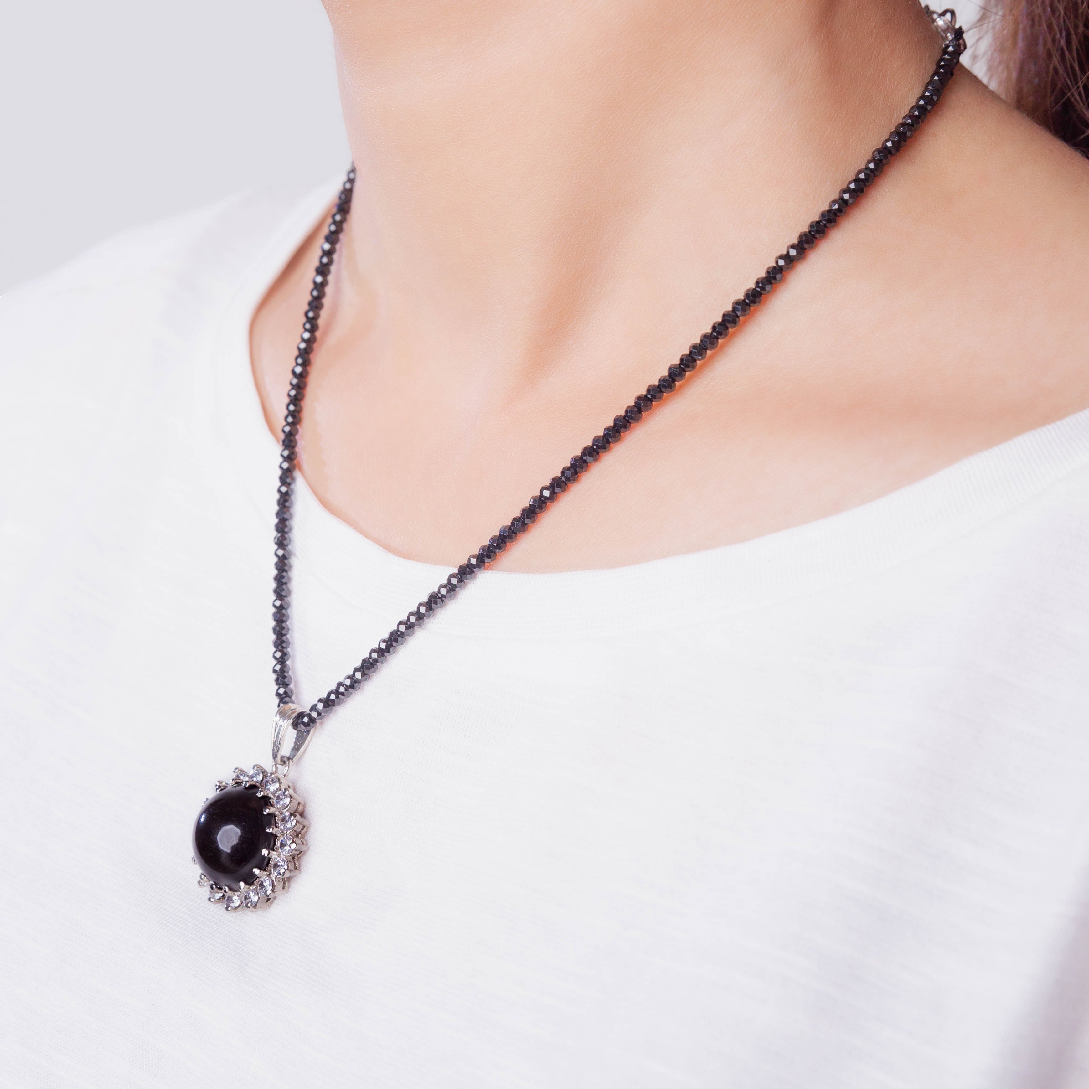 Niz & Aly Onyx Noir locket necklace featuring a polished black stone pendant on a beaded chain worn by a model