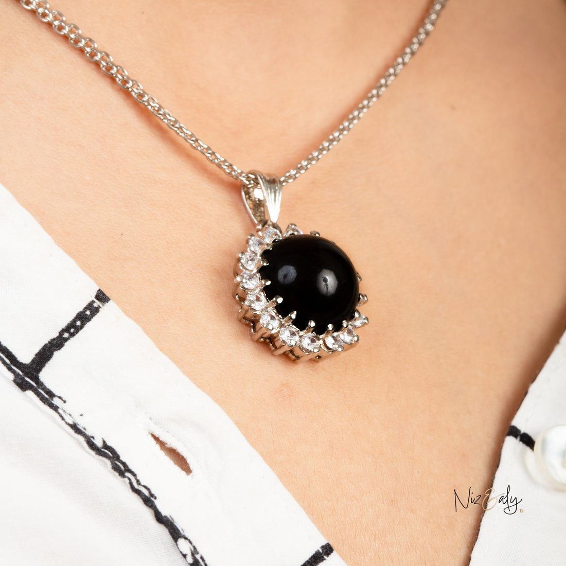 Niz & Aly black onyx cabochon pendant necklace with sparkling cubic zirconia accents worn on a silver chain