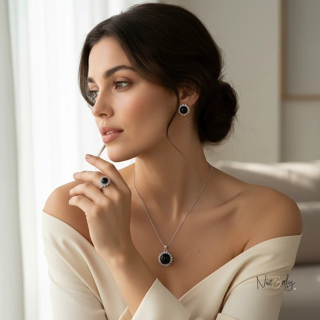 Niz & Aly black onyx cabochon pendant set with sparkling cubic zirconia worn by a woman in a white off-shoulder top.