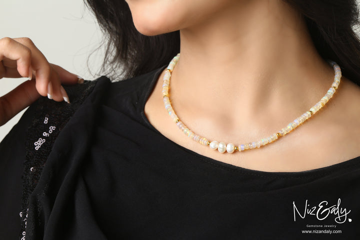 Niz & Aly Lunar Grace necklace featuring Ethiopian opal beads, three freshwater pearls, and gold spacers on a model.