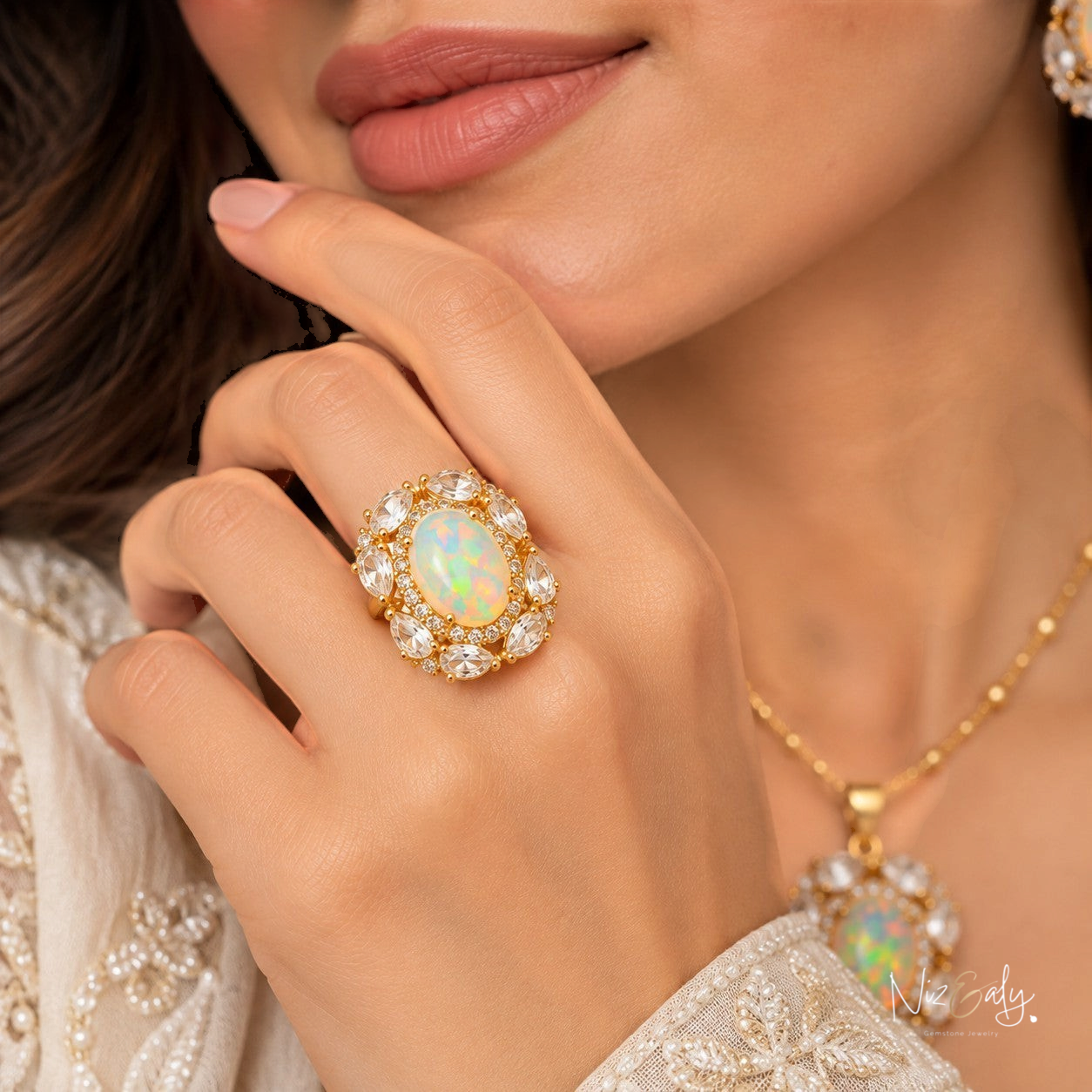 Niz & Aly gold-tone sterling silver ring with an oval opal center and marquise-cut clear quartz halo on a woman's hand