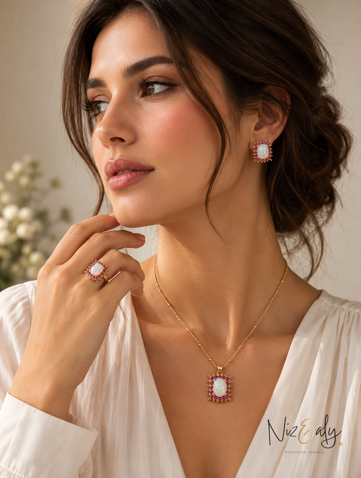 Niz & Aly jewelry set featuring opal, pink ruby, and green emerald stones in gold-tone settings worn by a woman.