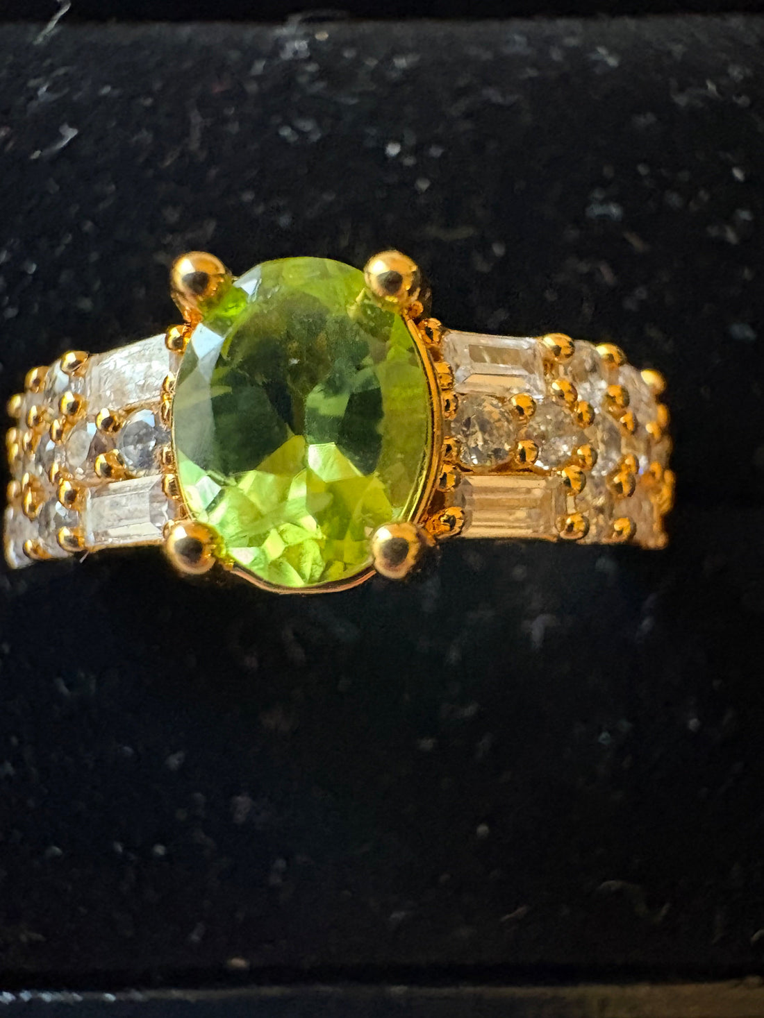 Niz & Aly gold-plated adjustable ring featuring a vibrant oval natural peridot and sparkling baguette cubic zirconia