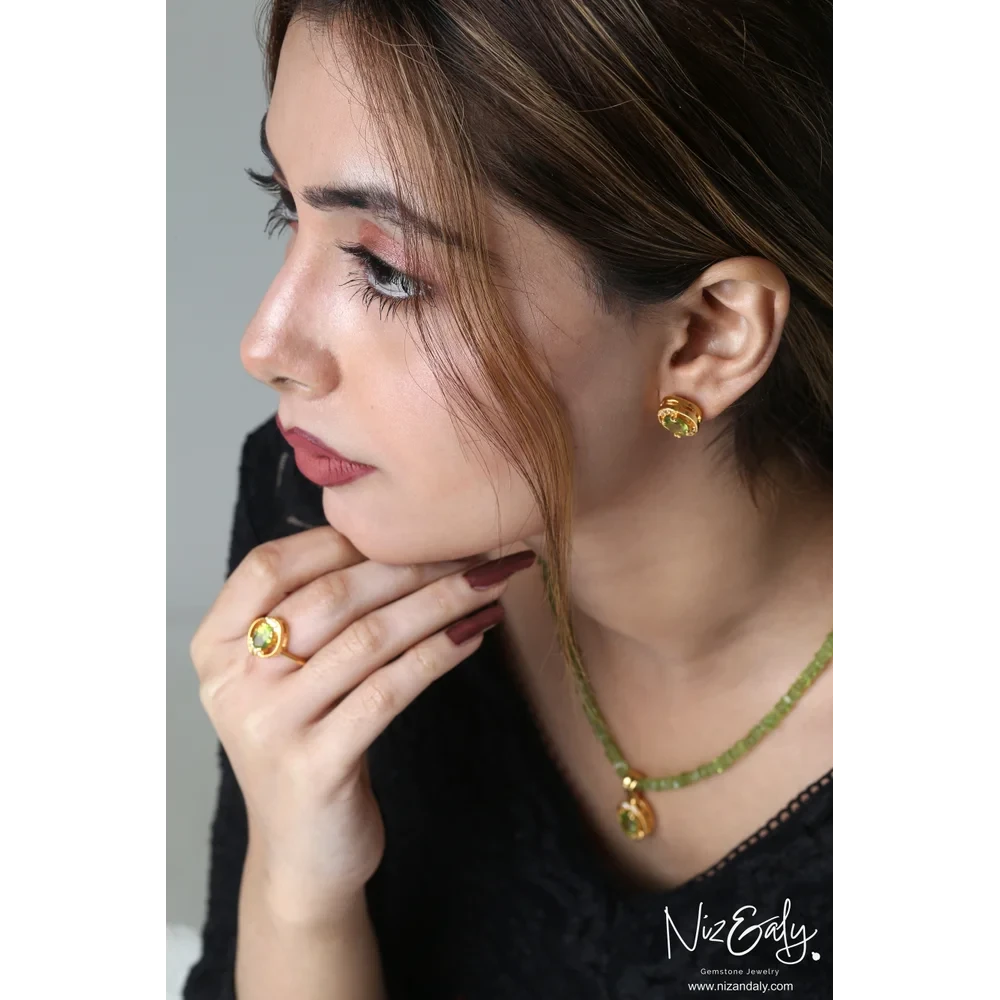 Niz & Aly oval Arizona peridot pendant set with gold-plated sterling silver necklace, earrings, and ring on a model.
