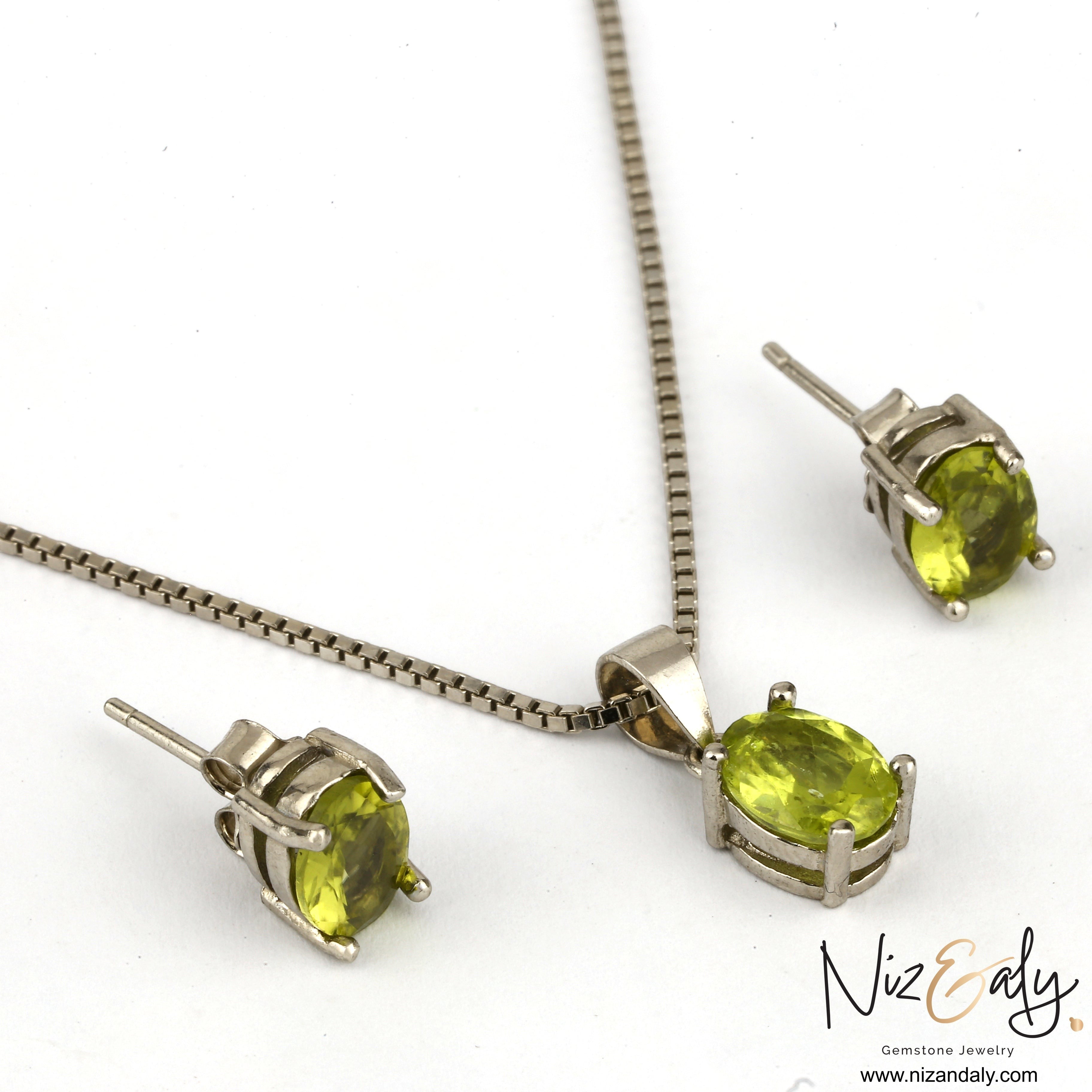 Niz & Aly oval peridot solitaire pendant and matching stud earrings set in silver, featuring vibrant green gemstones.
