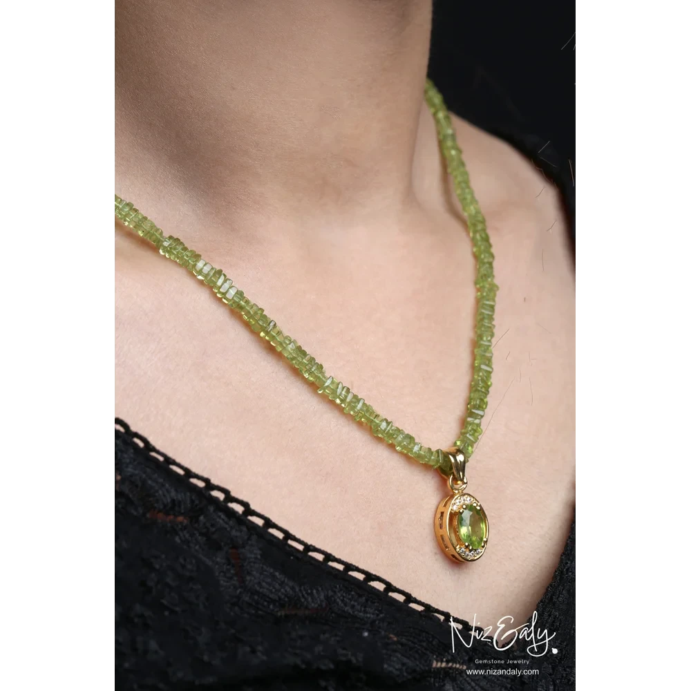 Niz & Aly oval Arizona peridot pendant on a beaded green gemstone necklace worn by a model in a black lace top.