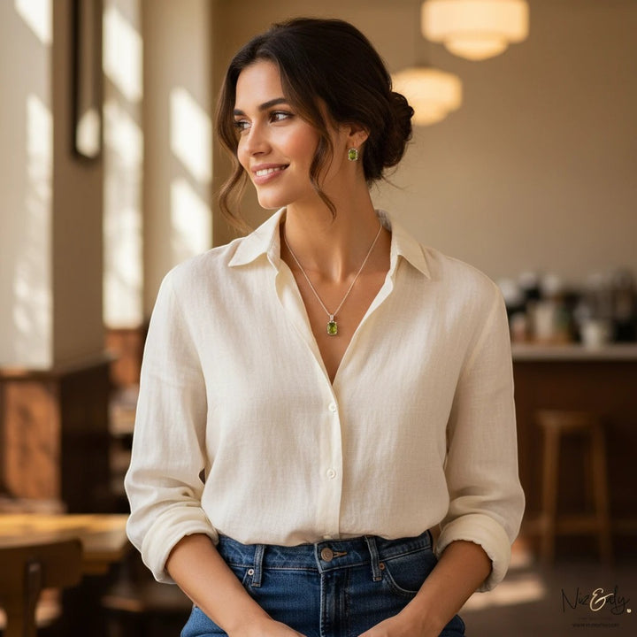 Niz & Aly oval peridot solitaire pendant and earring set worn by a woman in a white linen shirt