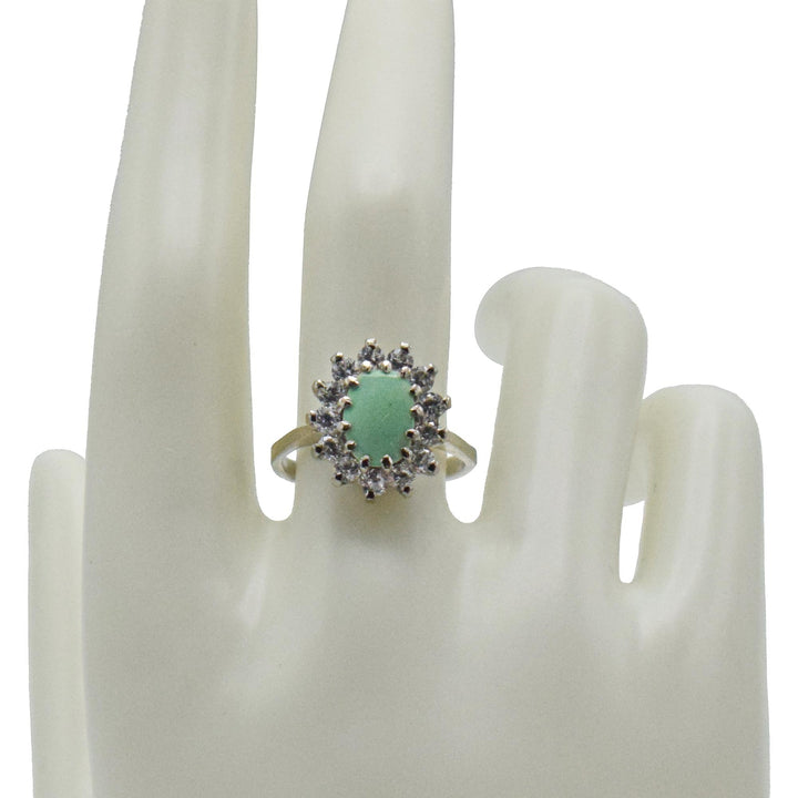Niz & Aly oval Persian turquoise ring featuring a central blue stone surrounded by a halo of sparkling white crystals.