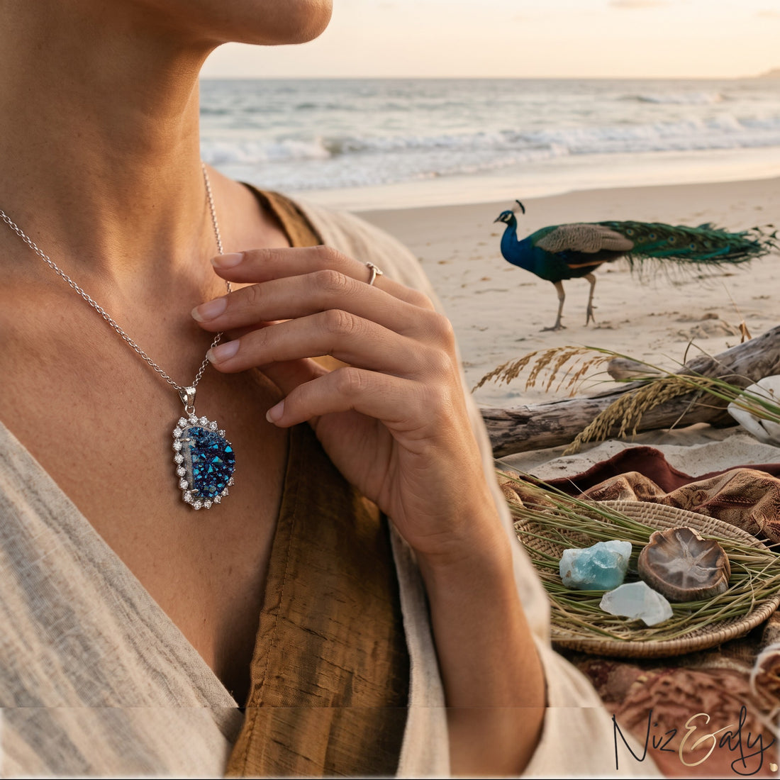 Niz & Aly peacock ore bornite pendant with iridescent blue and purple crystals on a sterling silver chain at the beach