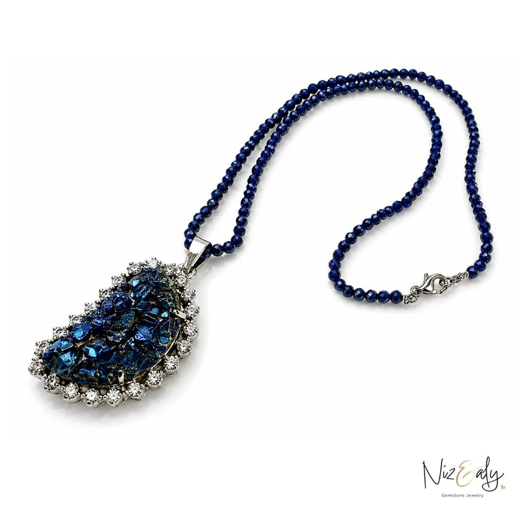 Niz & Aly peacock ore bornite pendant necklace with faceted blue lapis lazuli beads and a crystal-set silver frame.