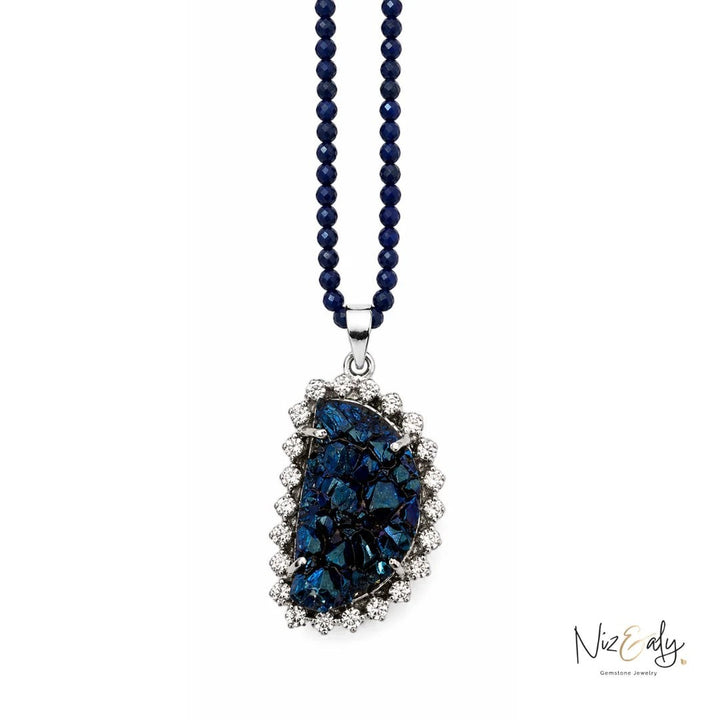 Niz & Aly peacock ore bornite pendant necklace with faceted blue lapis lazuli beads and a sparkling crystal halo setting.