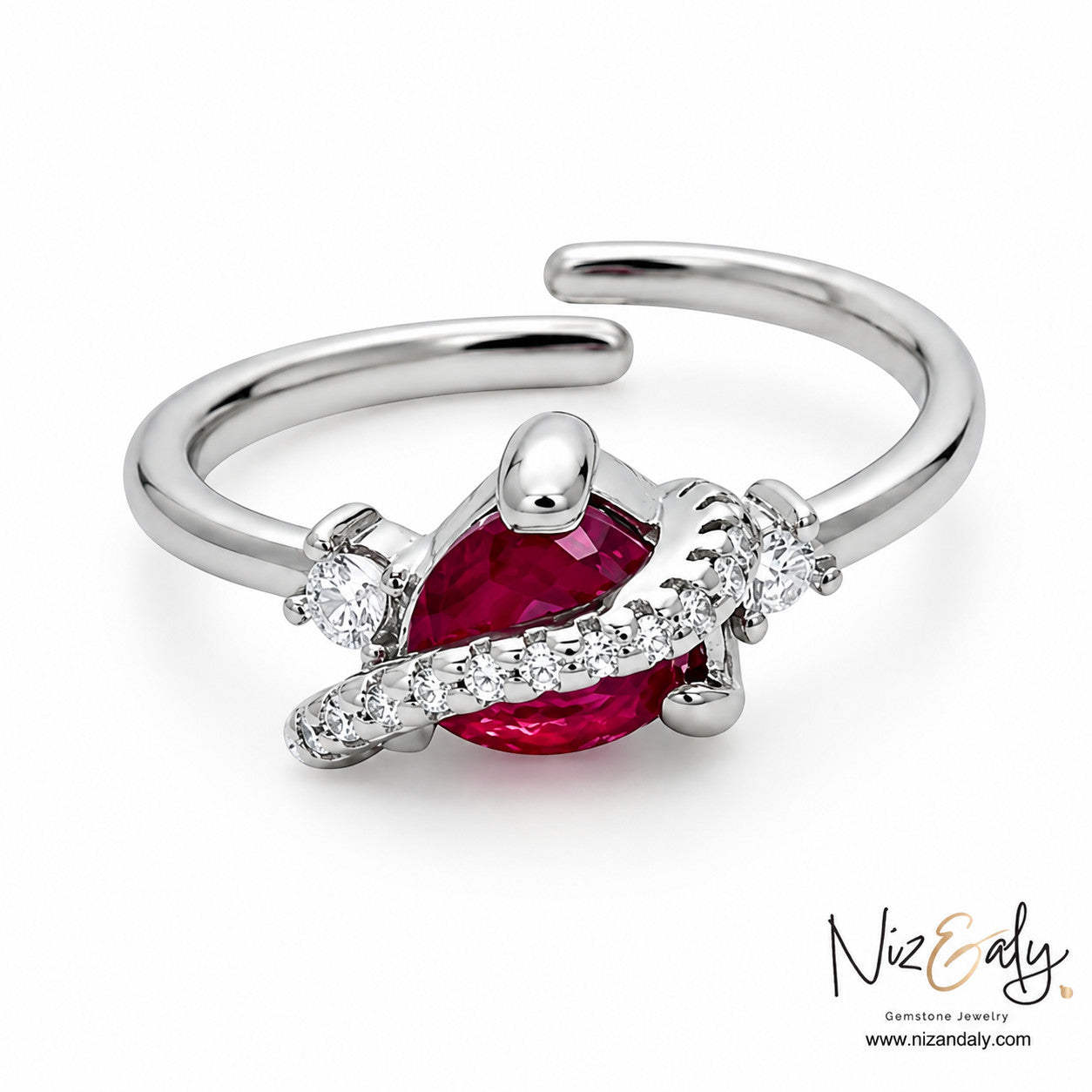 Niz & Aly pear-cut ruby ring in silver with a curved diamond-accented band on a white background.