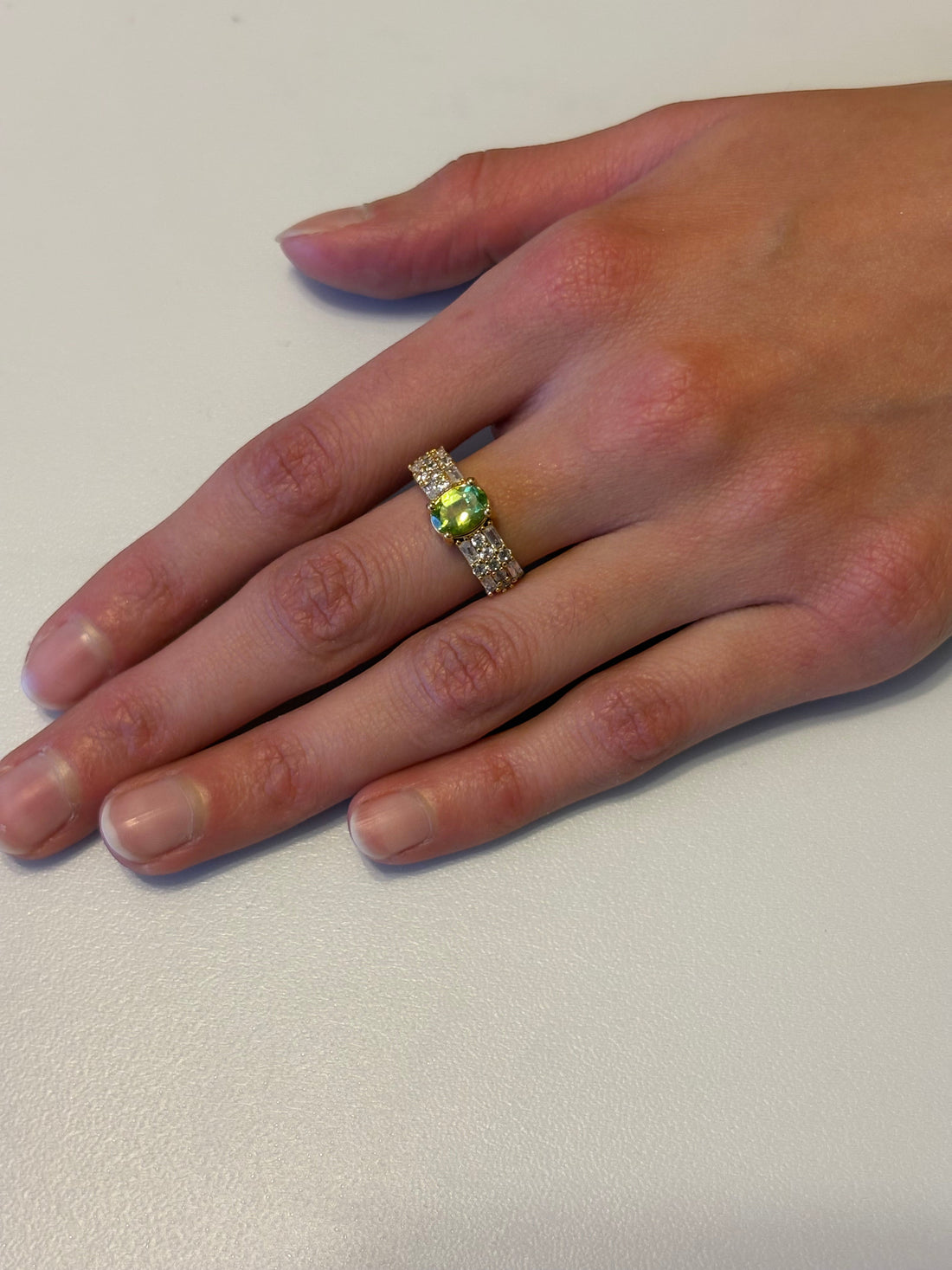 Niz & Aly natural apple green peridot ring with gold plating and sparkling cubic zirconia on a hand