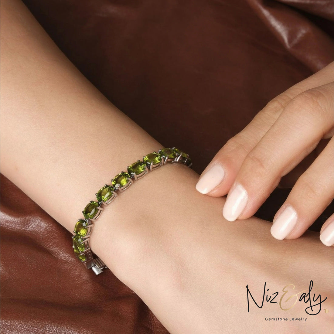 Niz & Aly tennis bracelet featuring oval-cut natural peridot gemstones set in rhodium-plated sterling silver on a wrist