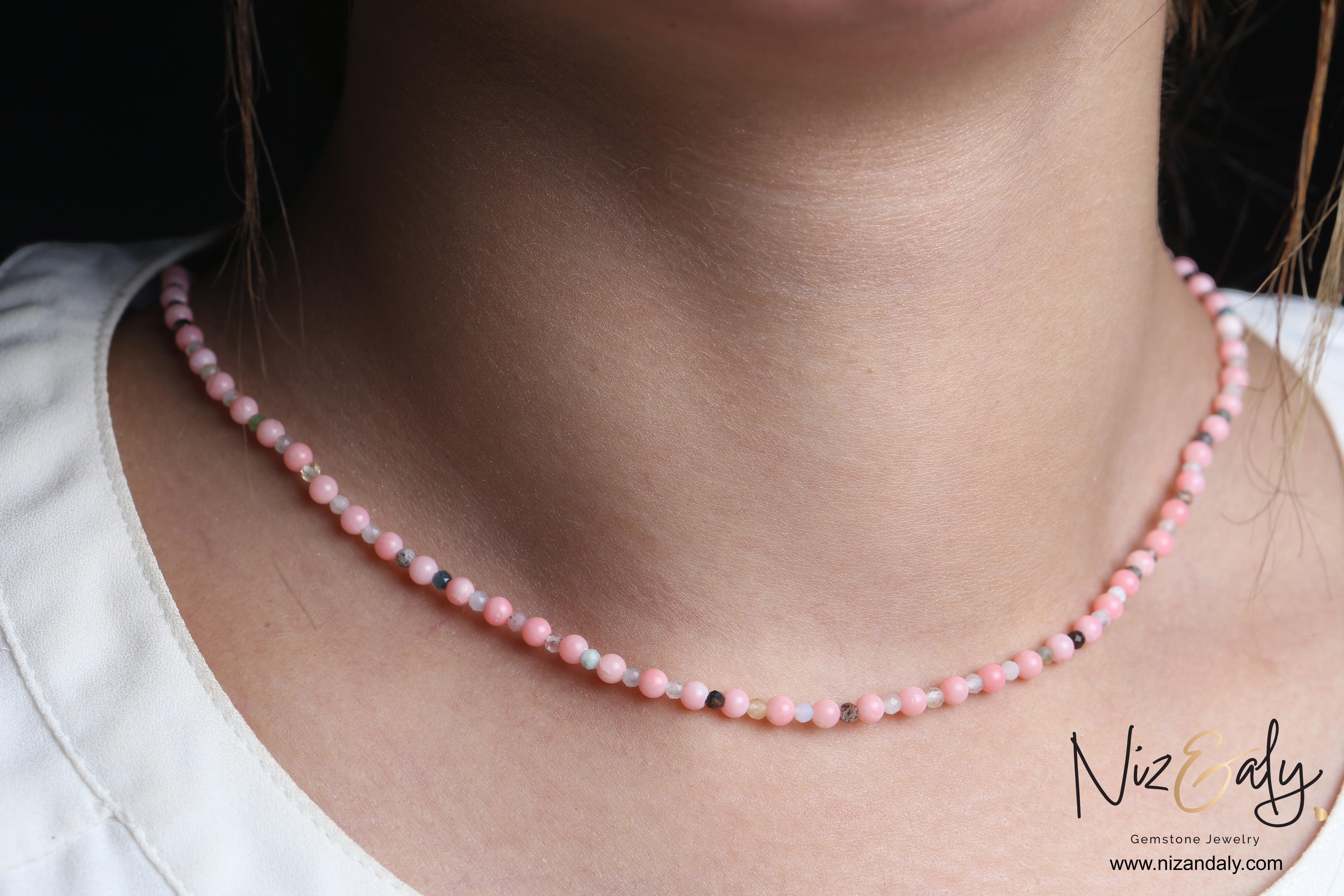 Niz & Aly dainty pink Aragonite bead necklace worn on a woman's neck, featuring soft pastel gemstone beads.