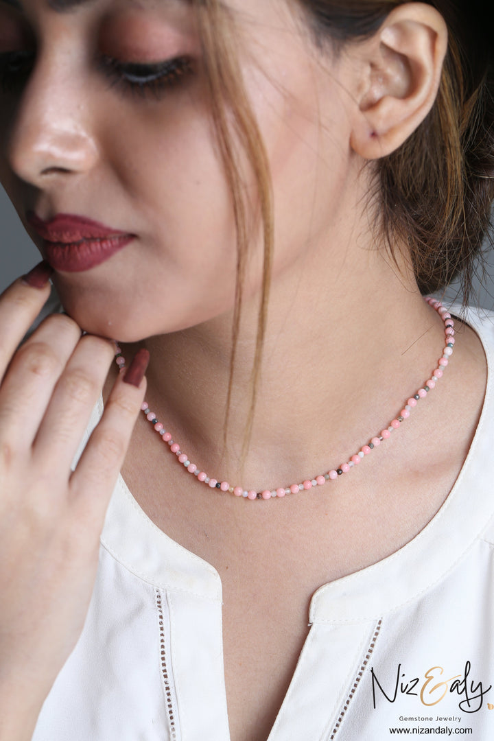 Niz & Aly dainty pink Aragonite bead necklace worn by a woman, featuring soft pastel stones and delicate accents.