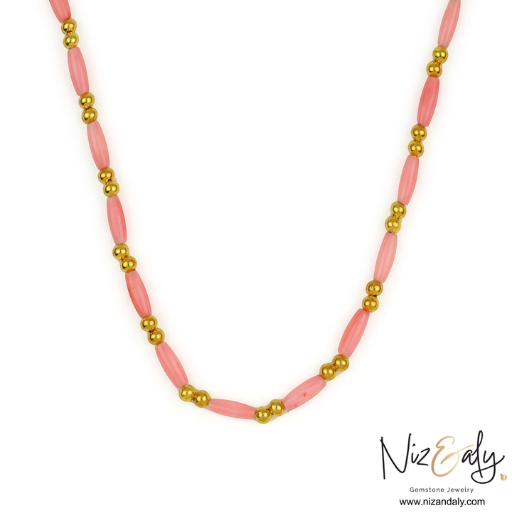 Niz & Aly dainty pink rice-shaped coral necklace with small gold beads on a white background