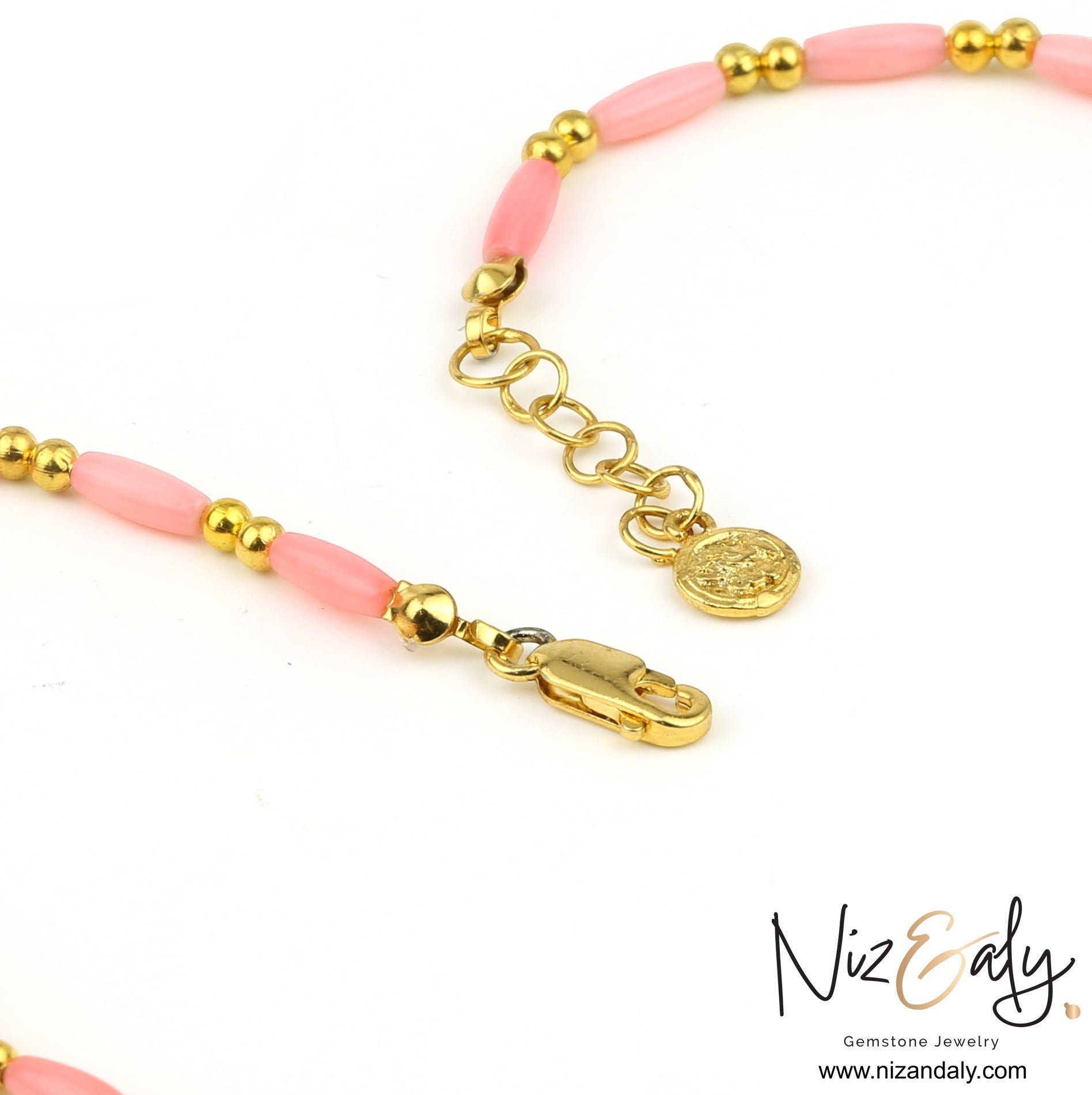Niz & Aly dainty pink rice-shaped coral necklace with gold beads and a lobster clasp closure on a white background.